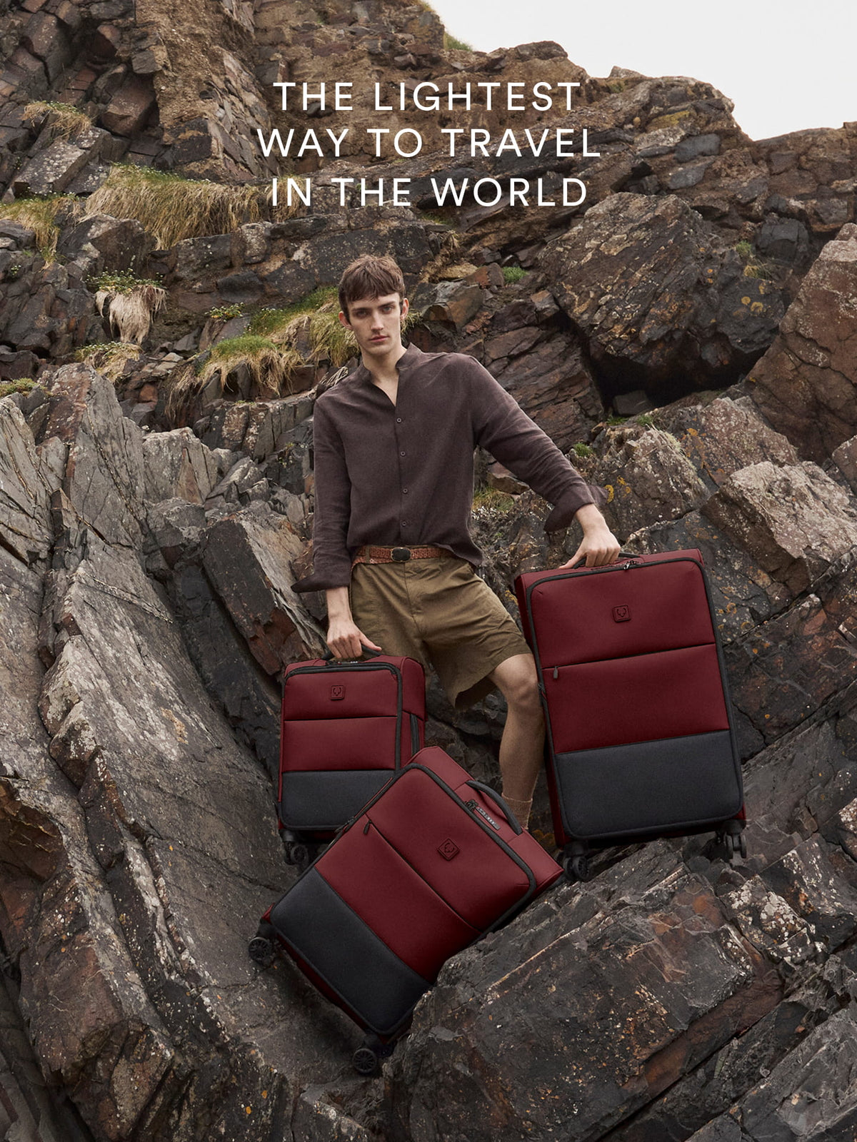 a man holding luggage on a rocky hill