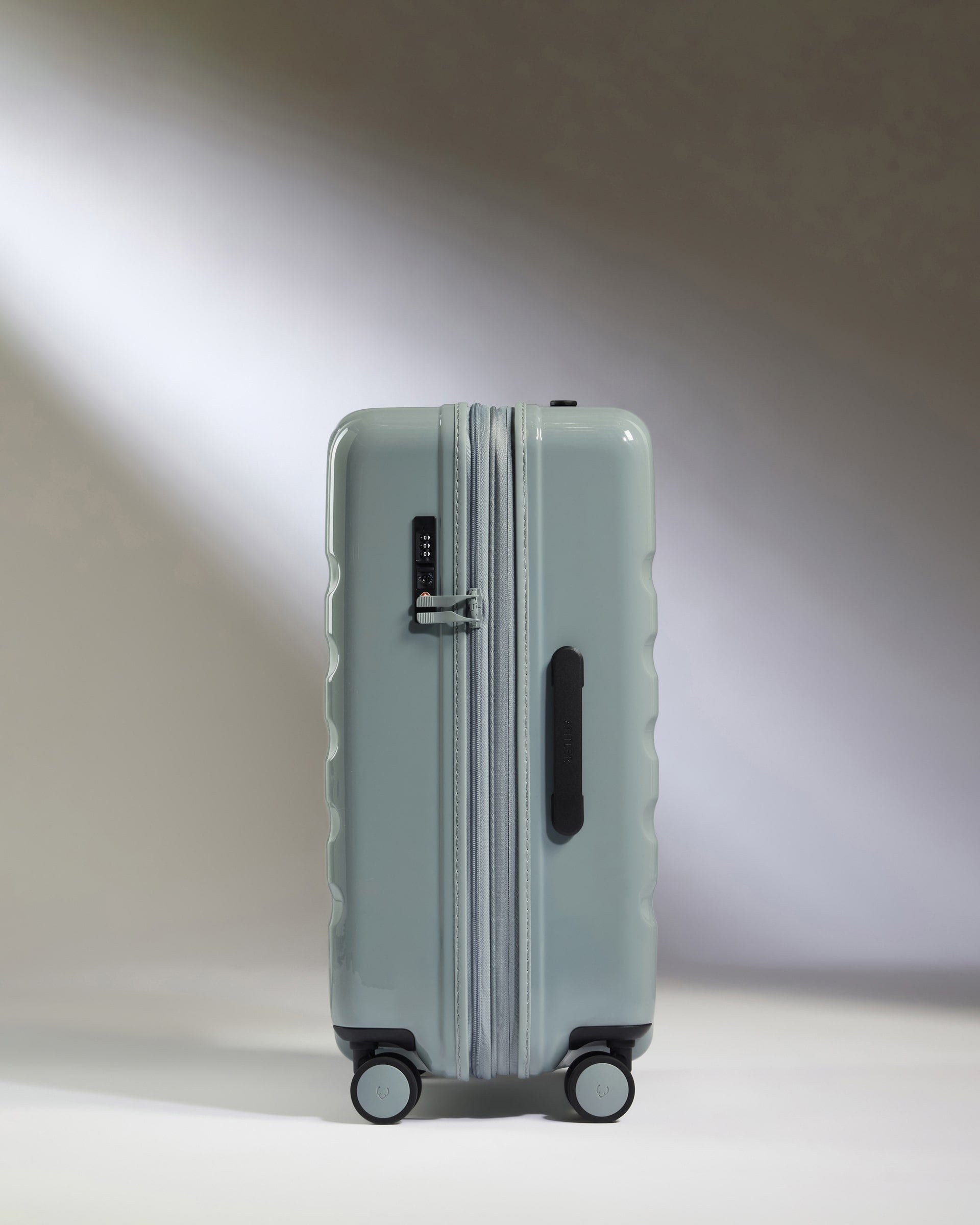 a light blue suitcase with wheels