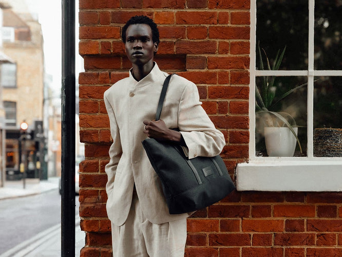 a man in a white suit holding a bag
