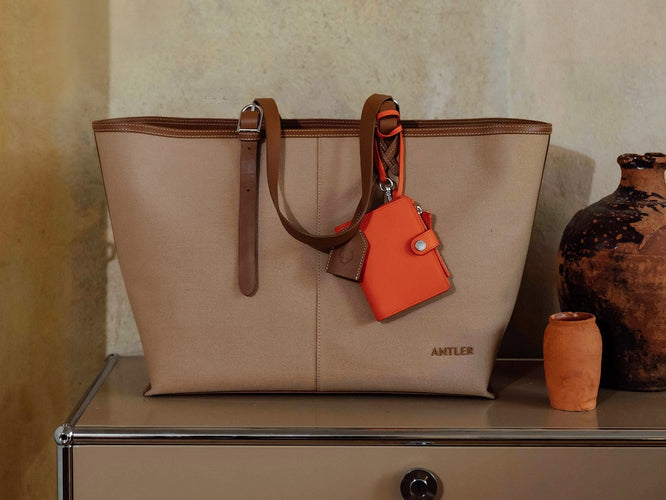 a tan purse with a red tag on it