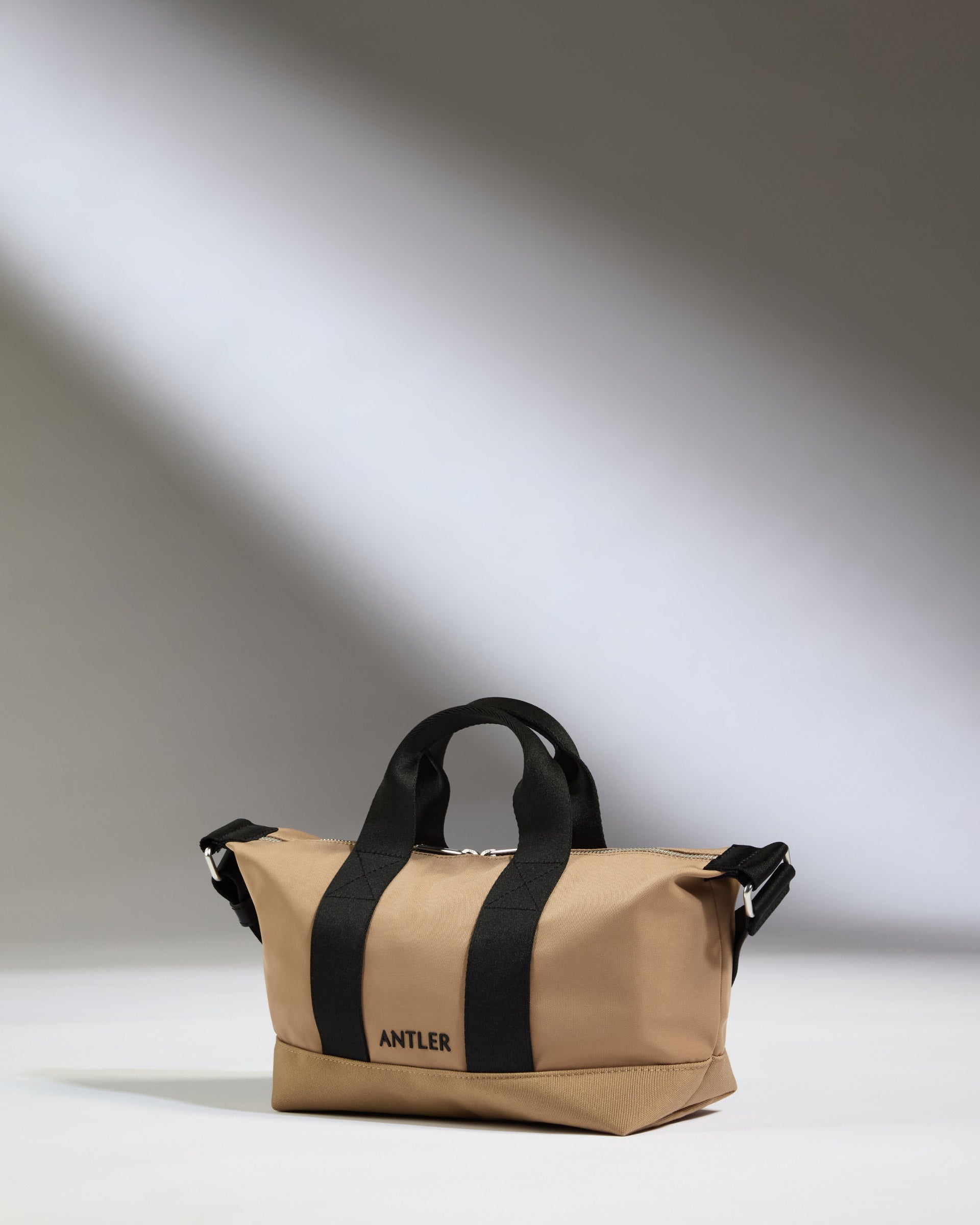 a tan bag with black straps
