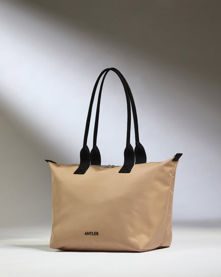 a beige bag with black handles