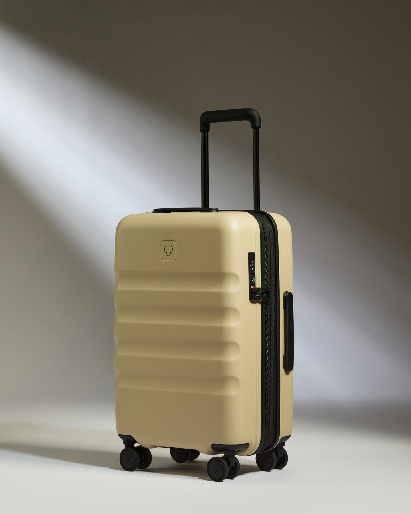 a tan suitcase with black wheels