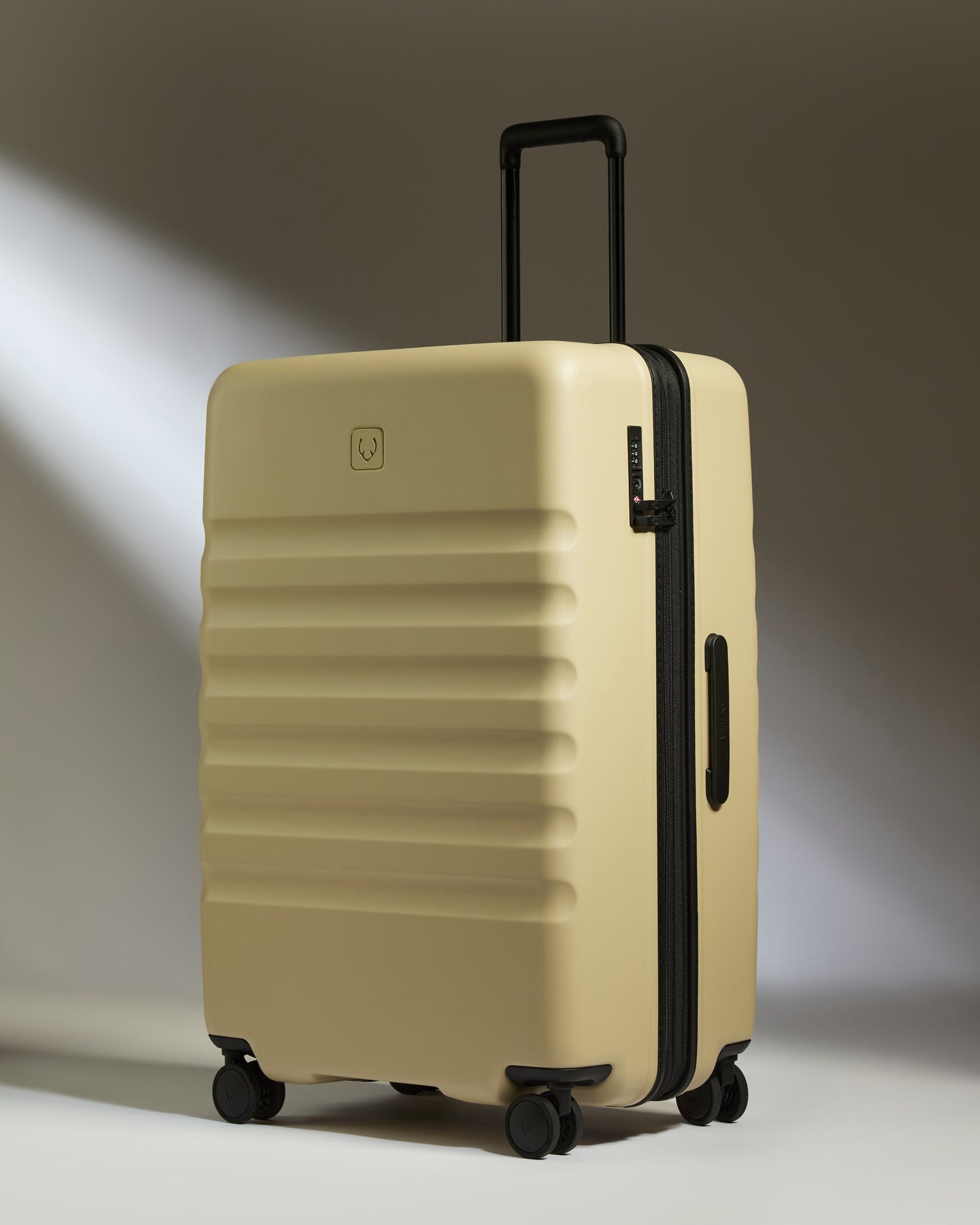 a tan suitcase with black wheels