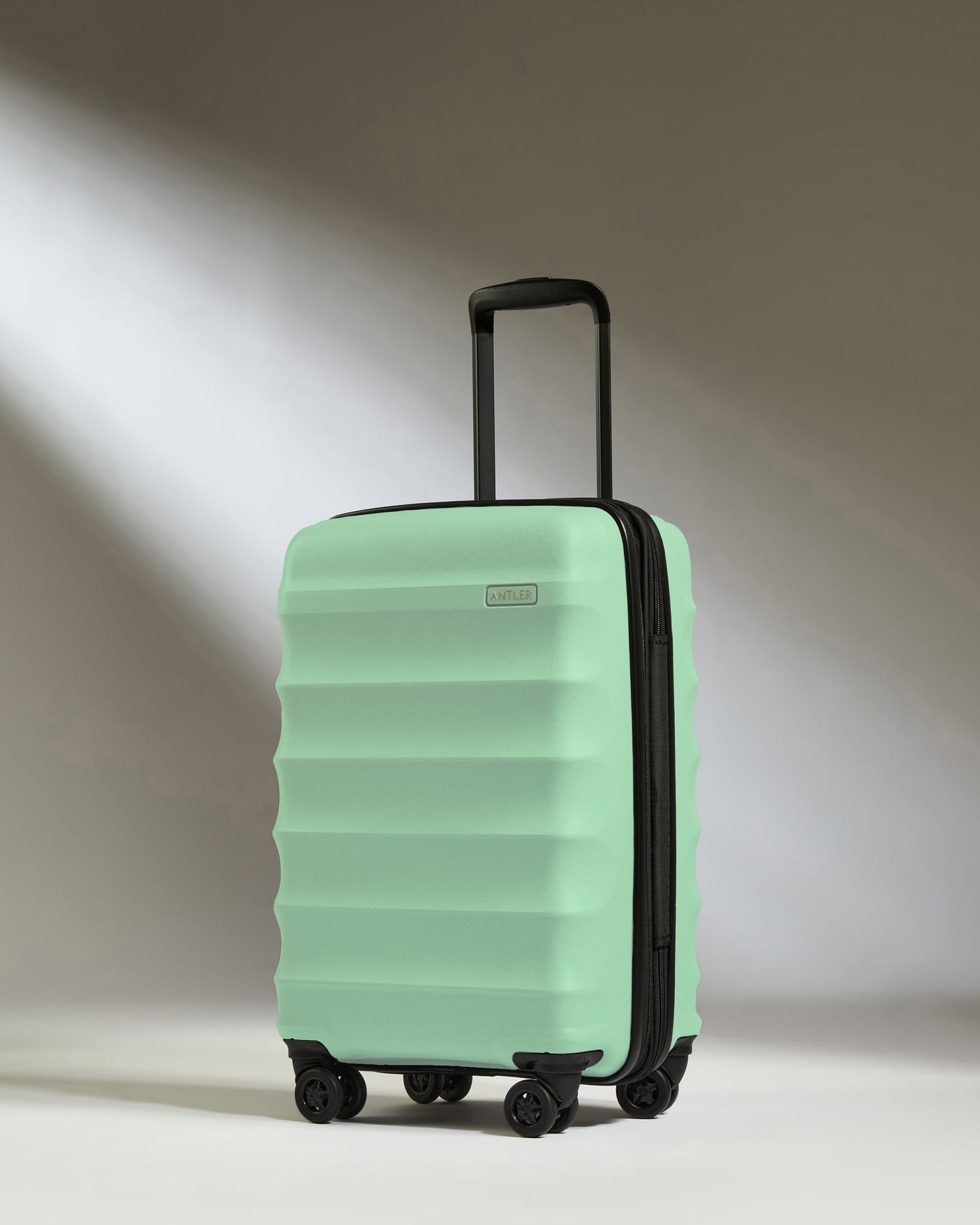 a light green suitcase with wheels