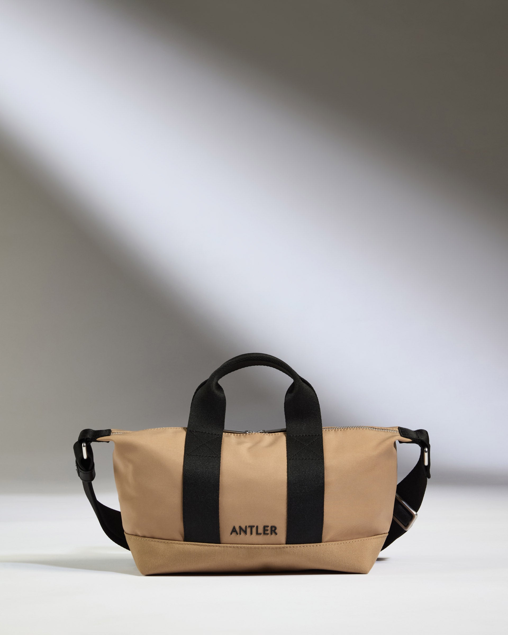a tan bag with black straps