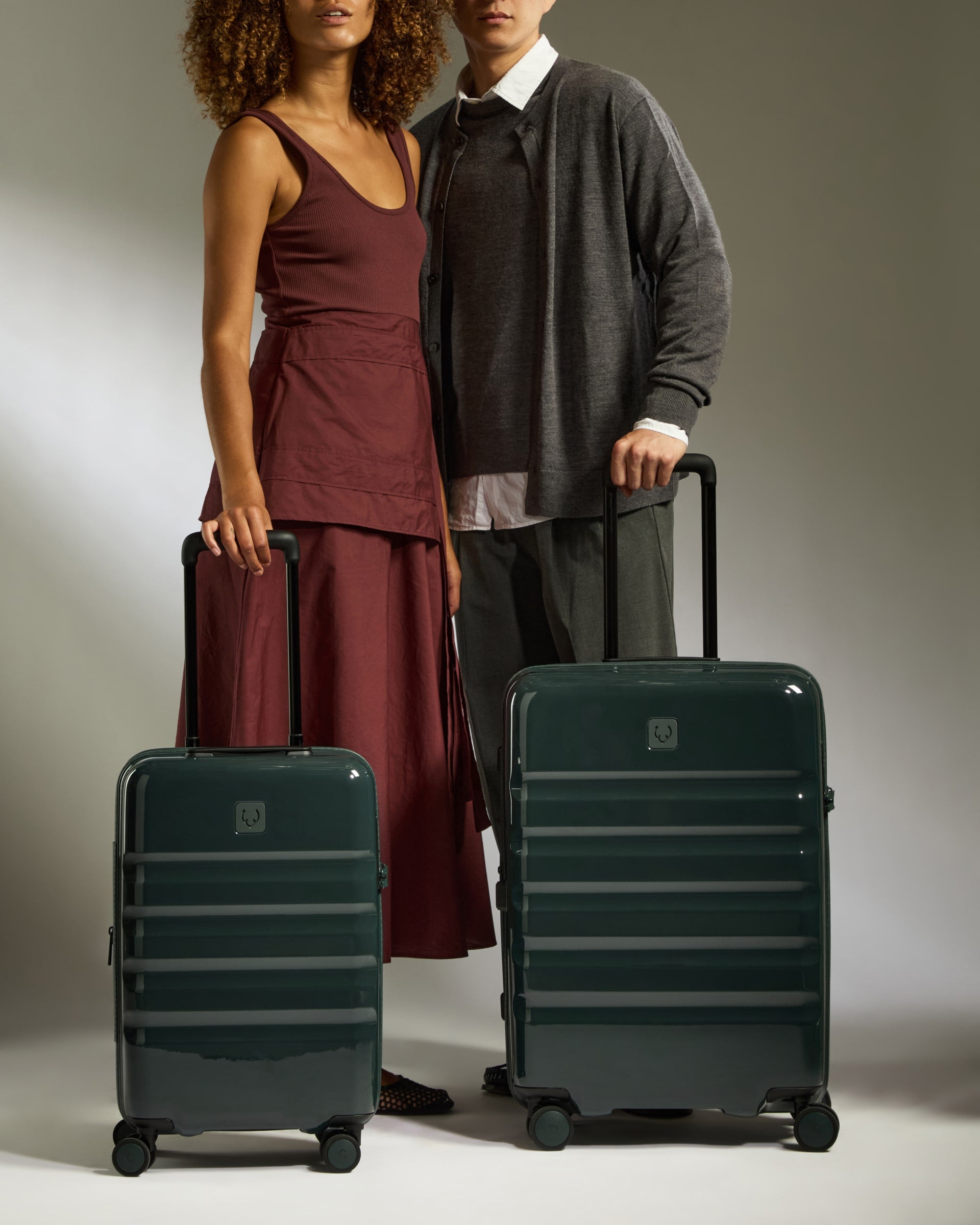 a man and woman standing next to luggage