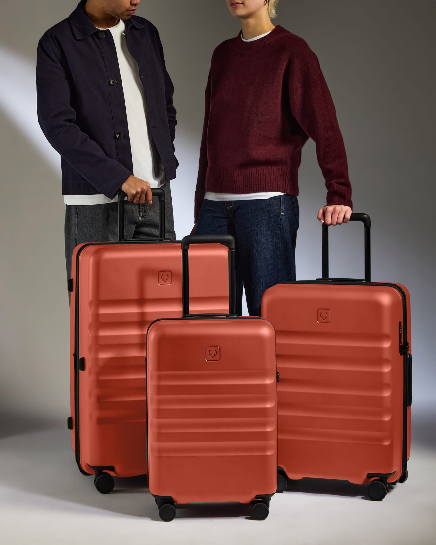 two men standing next to a group of luggage