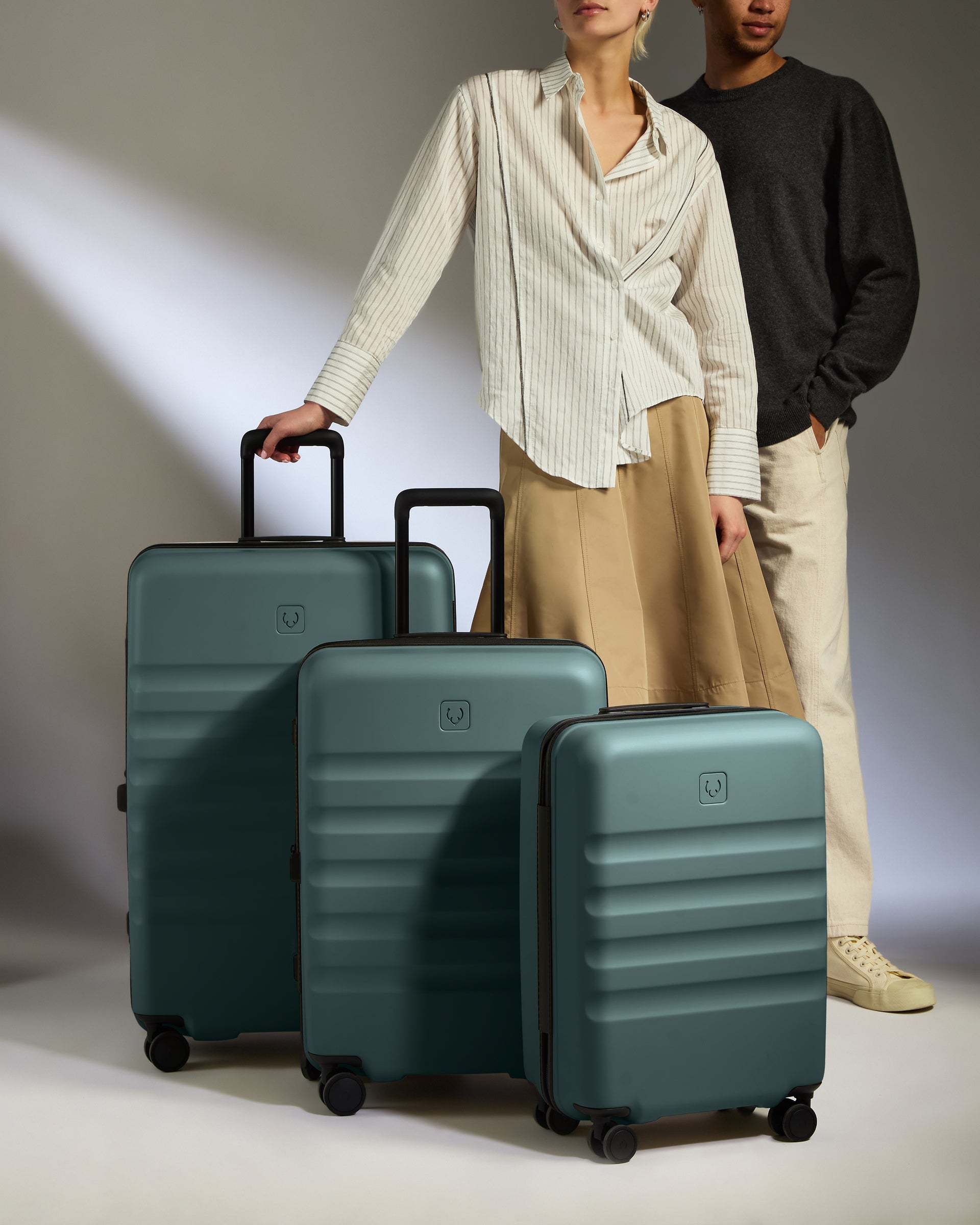 a man and woman standing next to a group of luggage