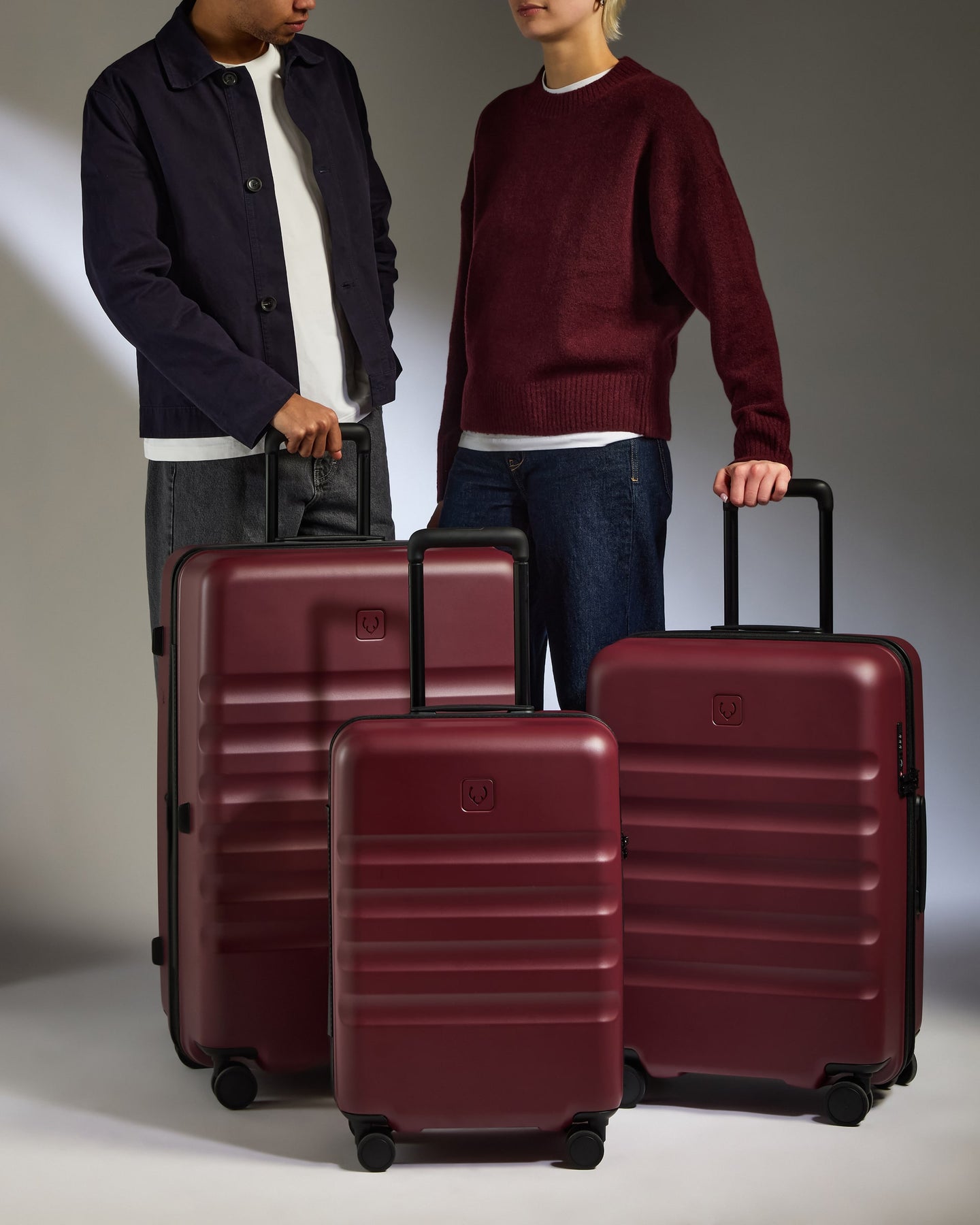 two men standing next to a group of luggage