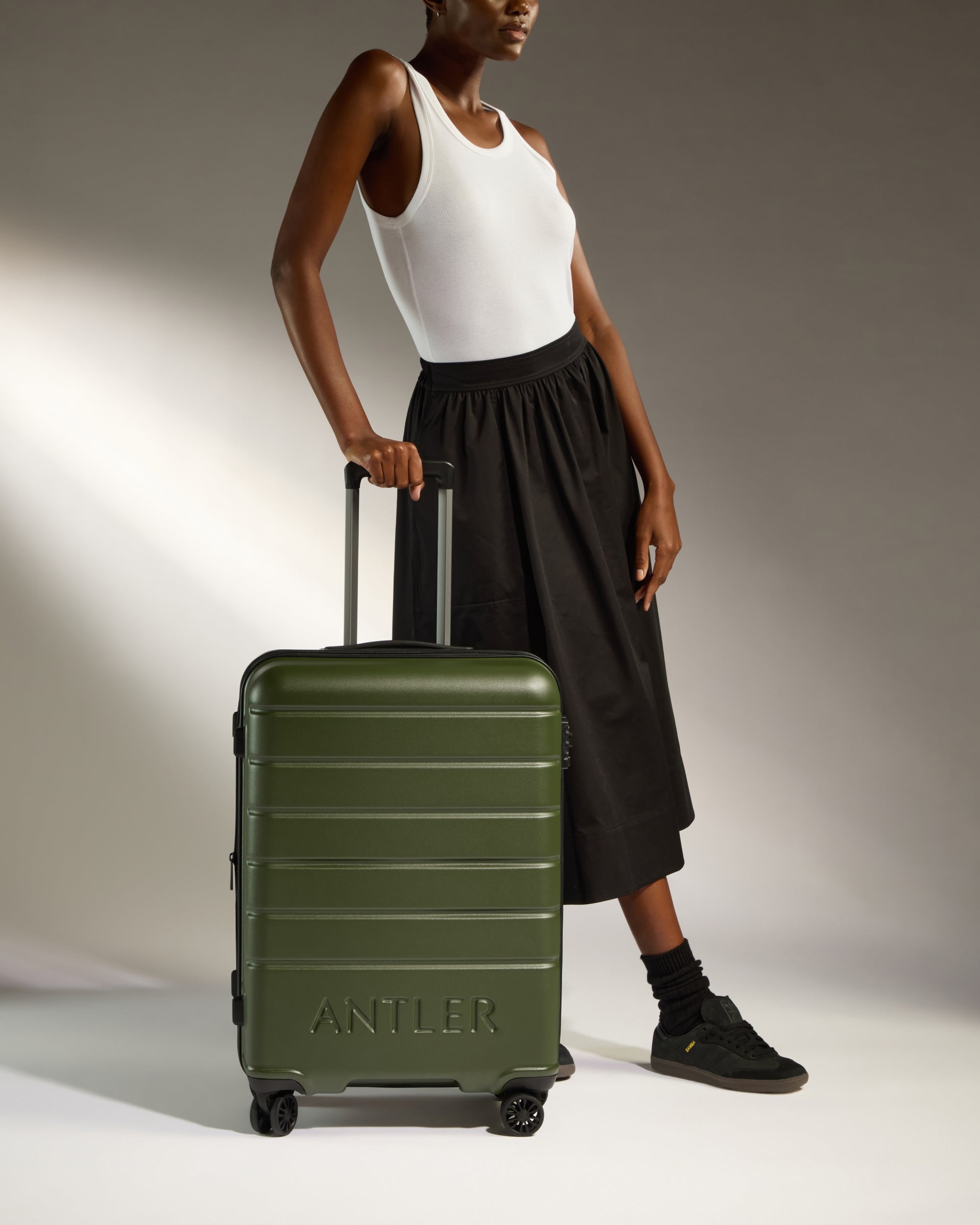 a woman standing next to a suitcase