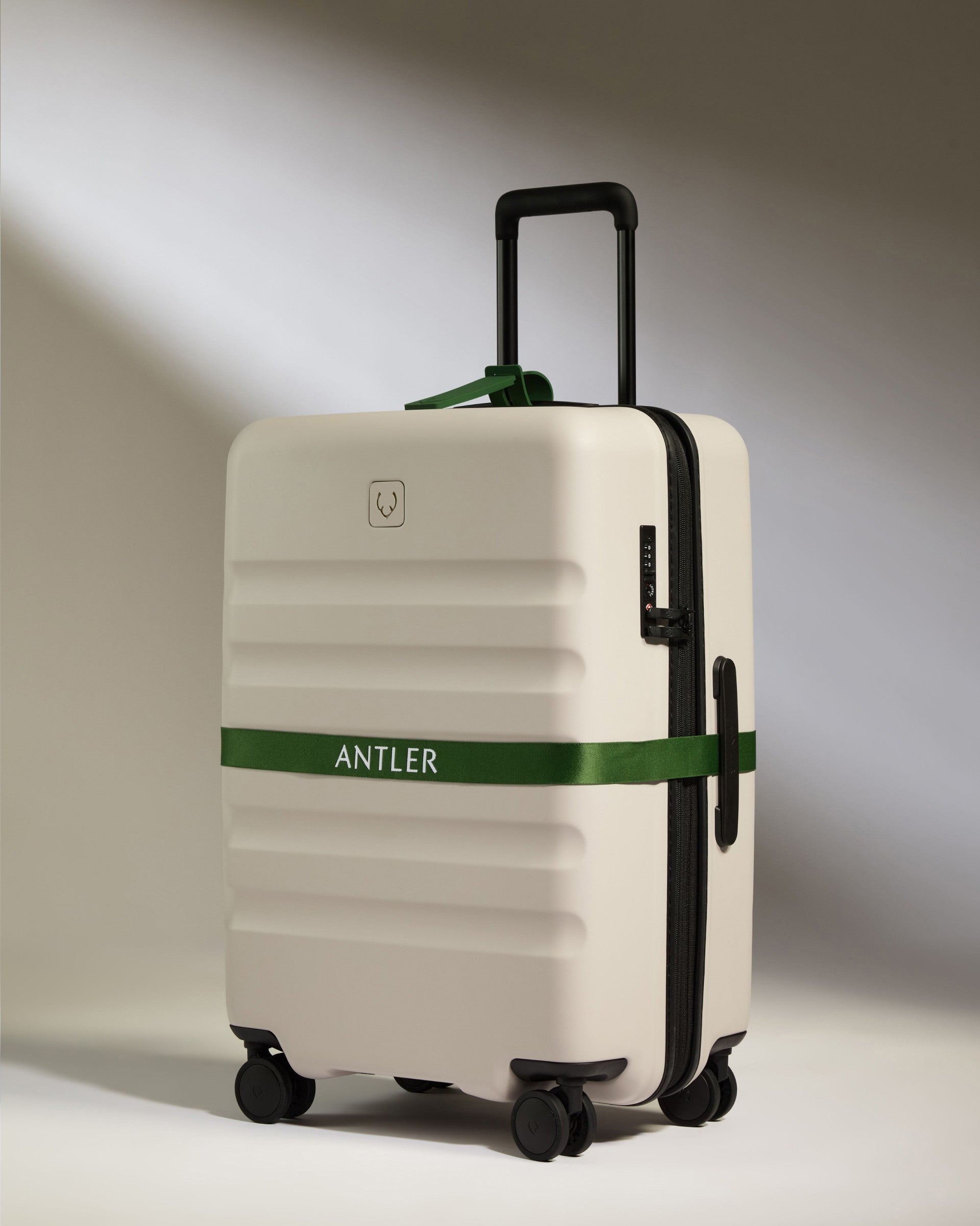 a white suitcase with a green band around it