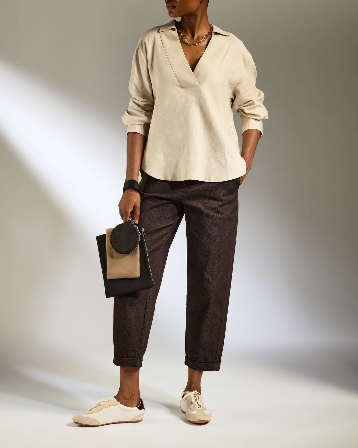 a woman in a white shirt and brown pants