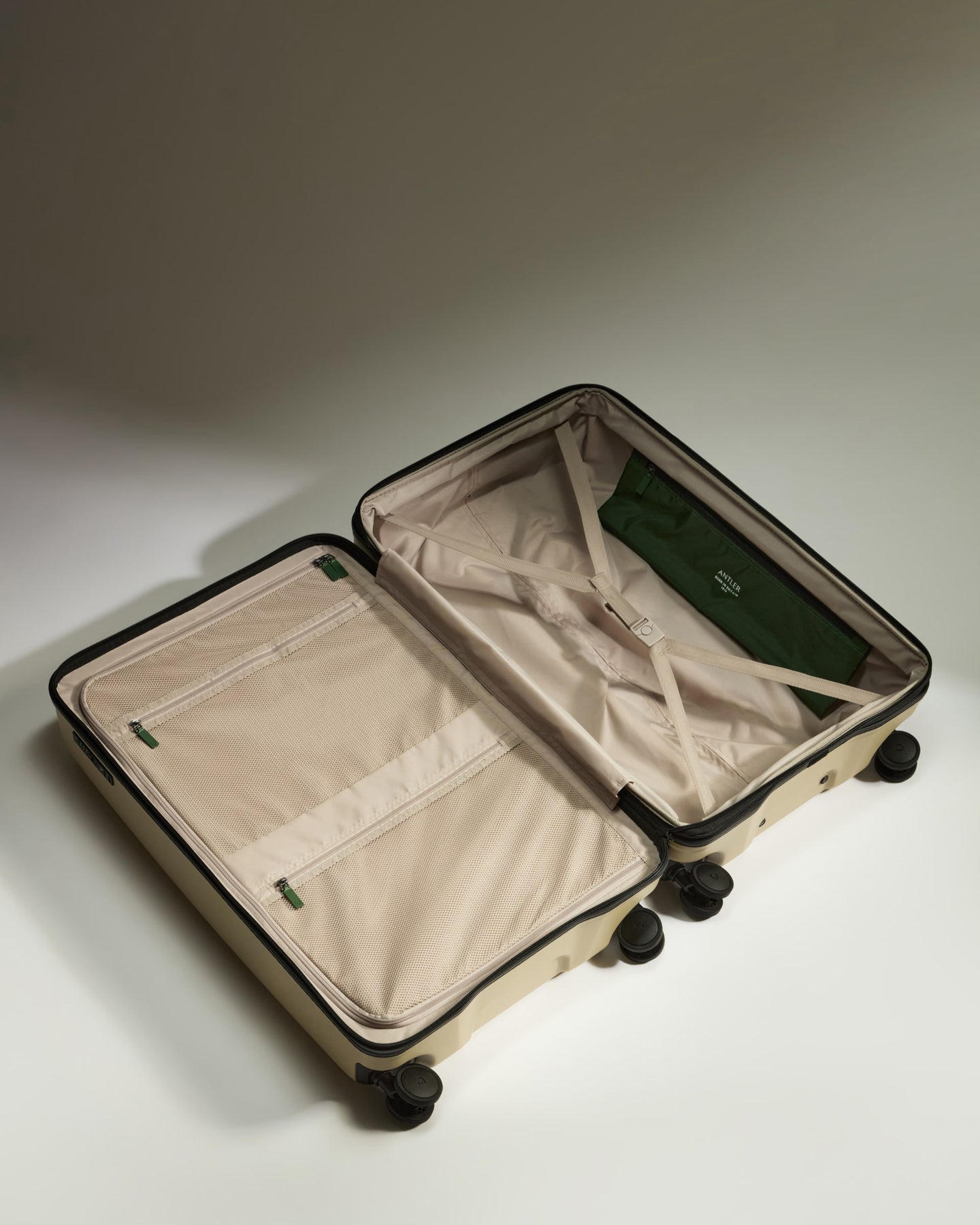 a suitcase with wheels and a green bag