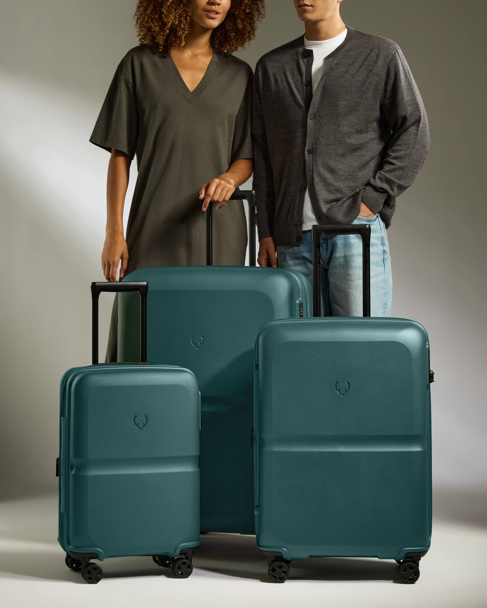 a man and woman standing next to a group of luggage