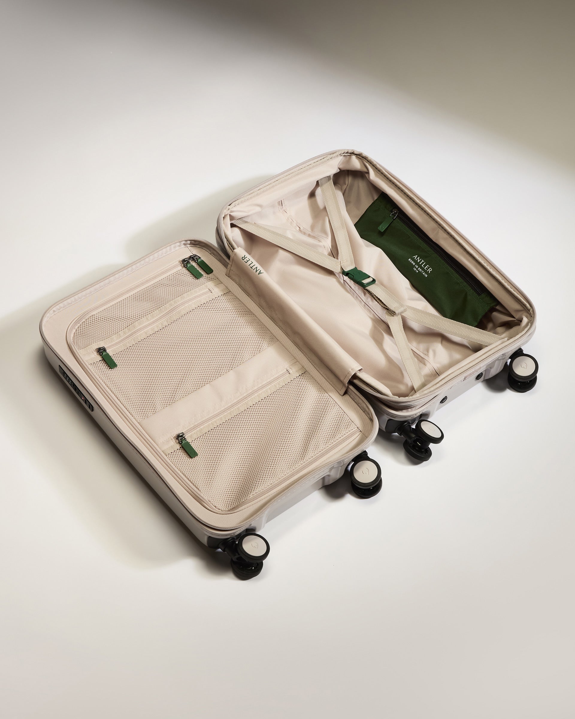 a suitcase with wheels and a green bag