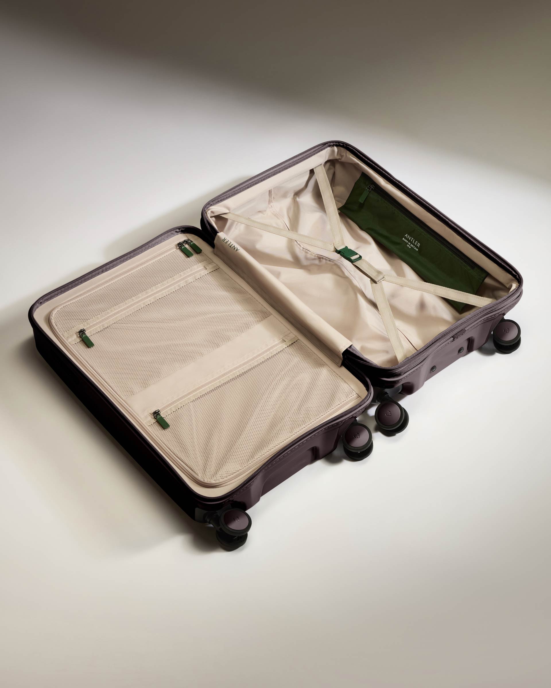 a suitcase with wheels and a green bag