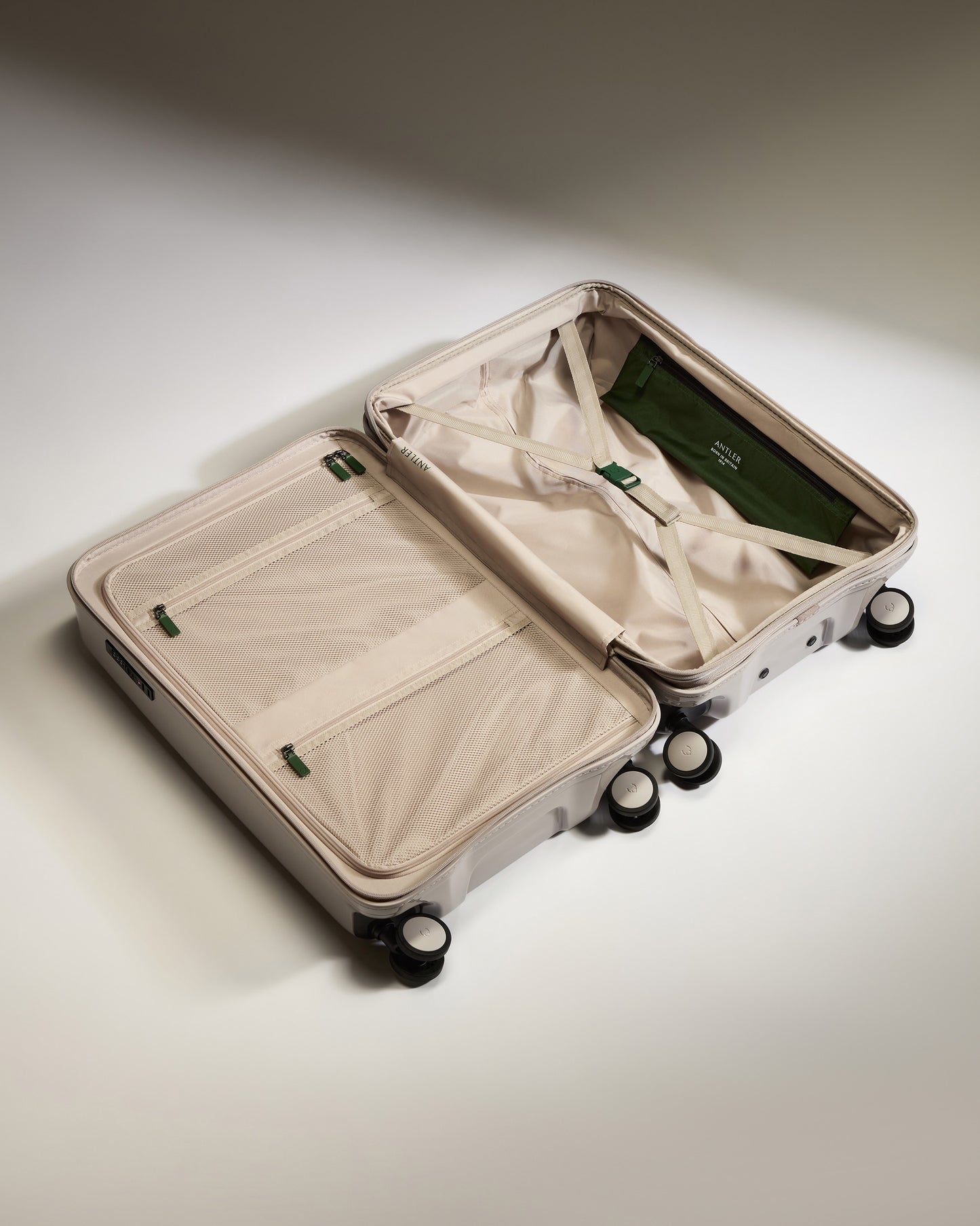 a suitcase with wheels and a green bag