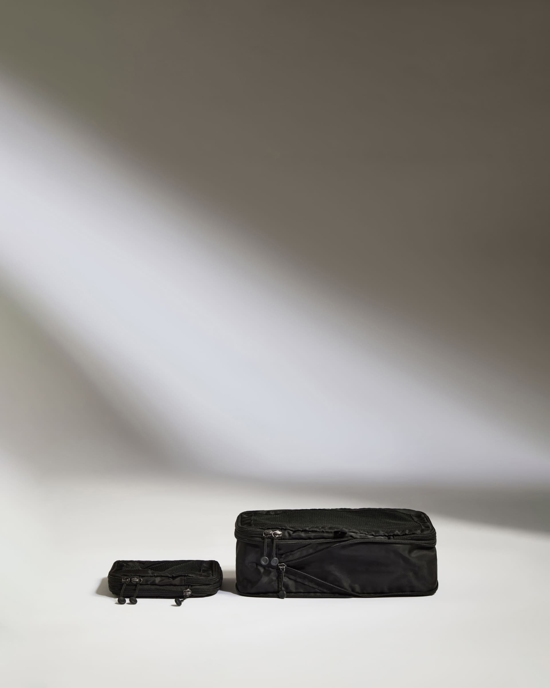 a black suitcases on a white surface