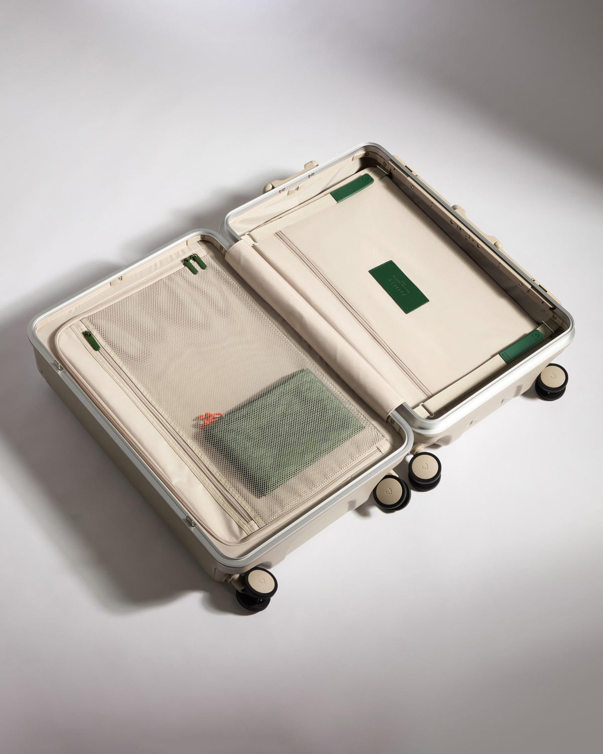 a suitcase with wheels and a green bag