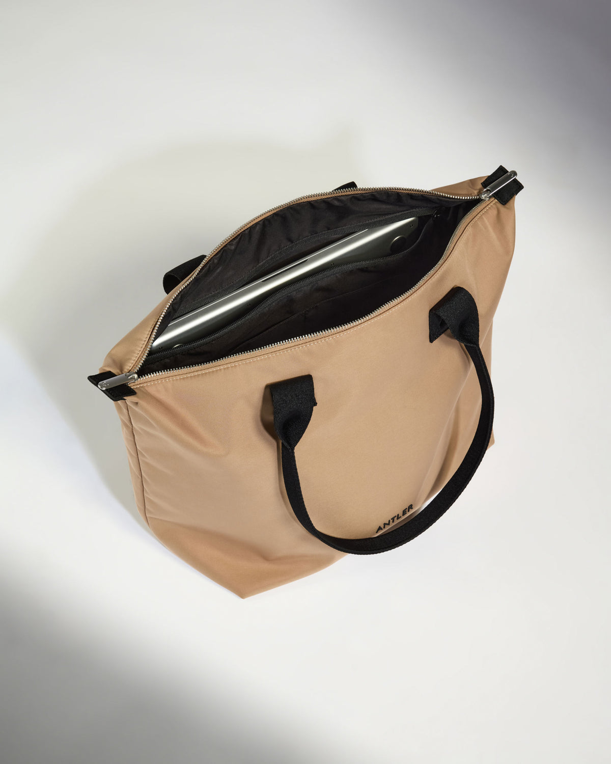 a tan bag with black handles