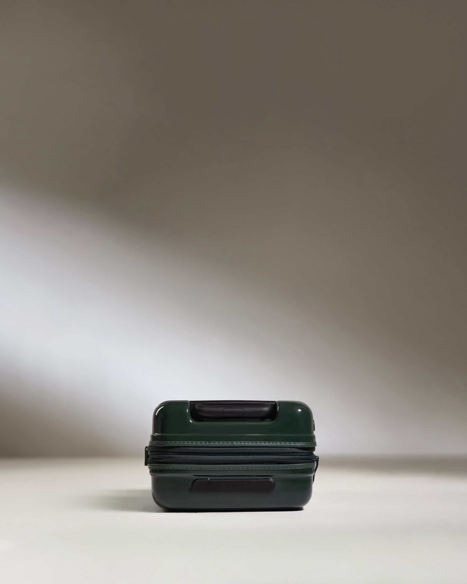 a green suitcase on a white surface