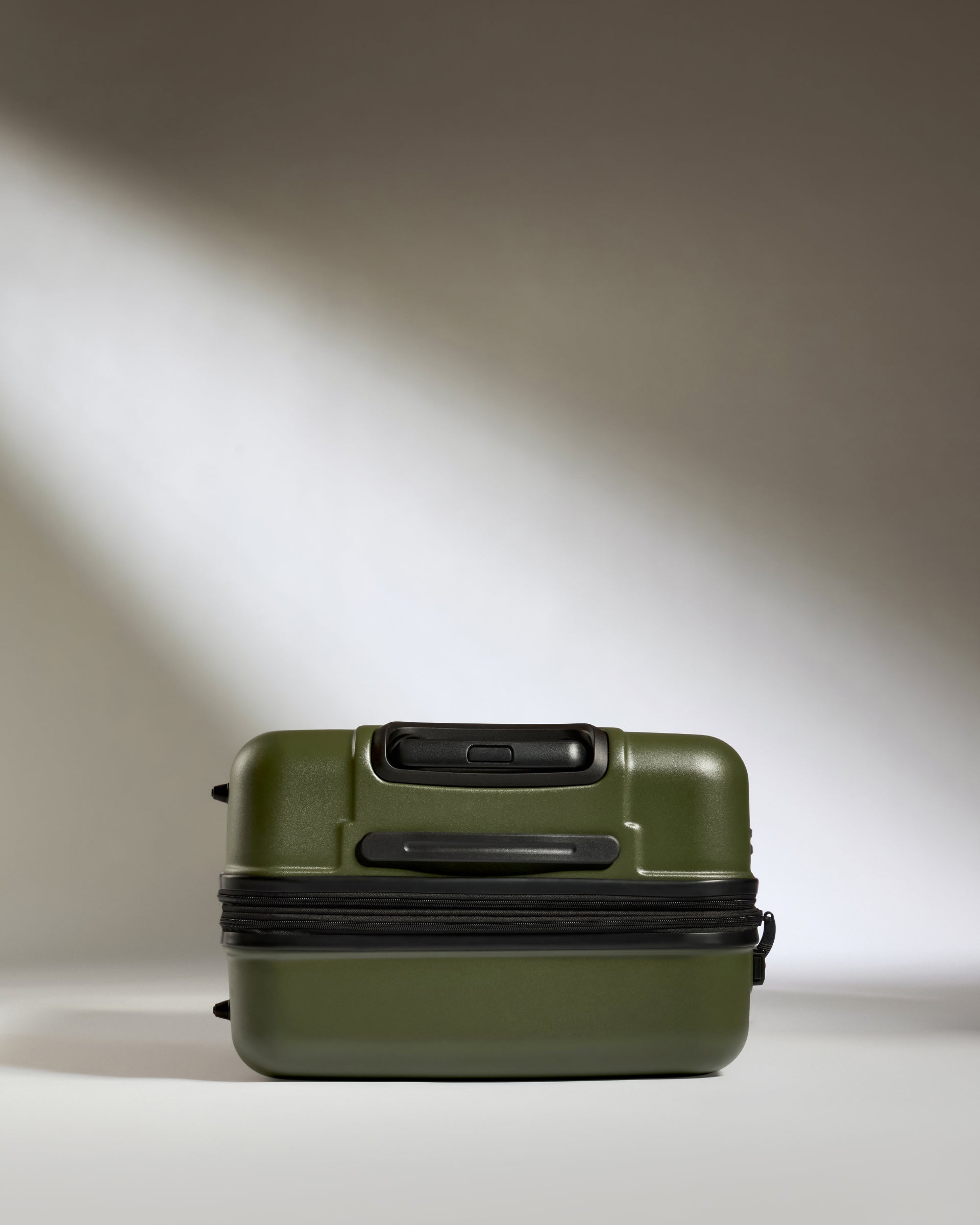 a green suitcase with a black zipper