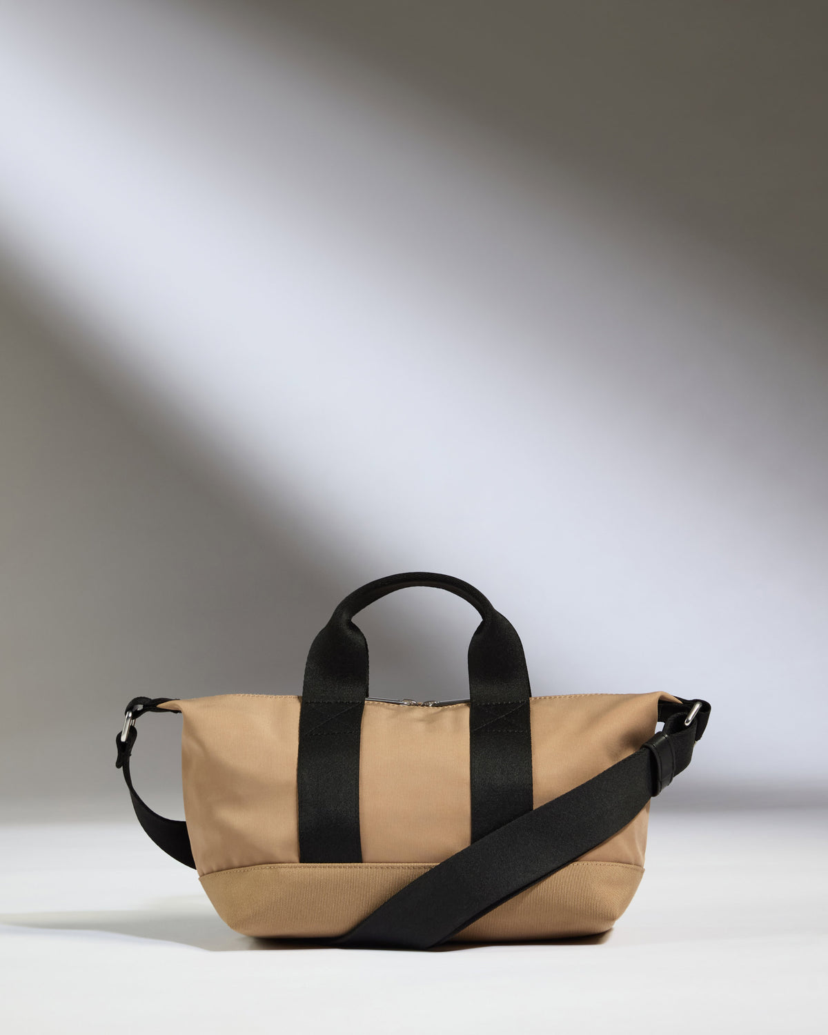 a tan bag with black straps