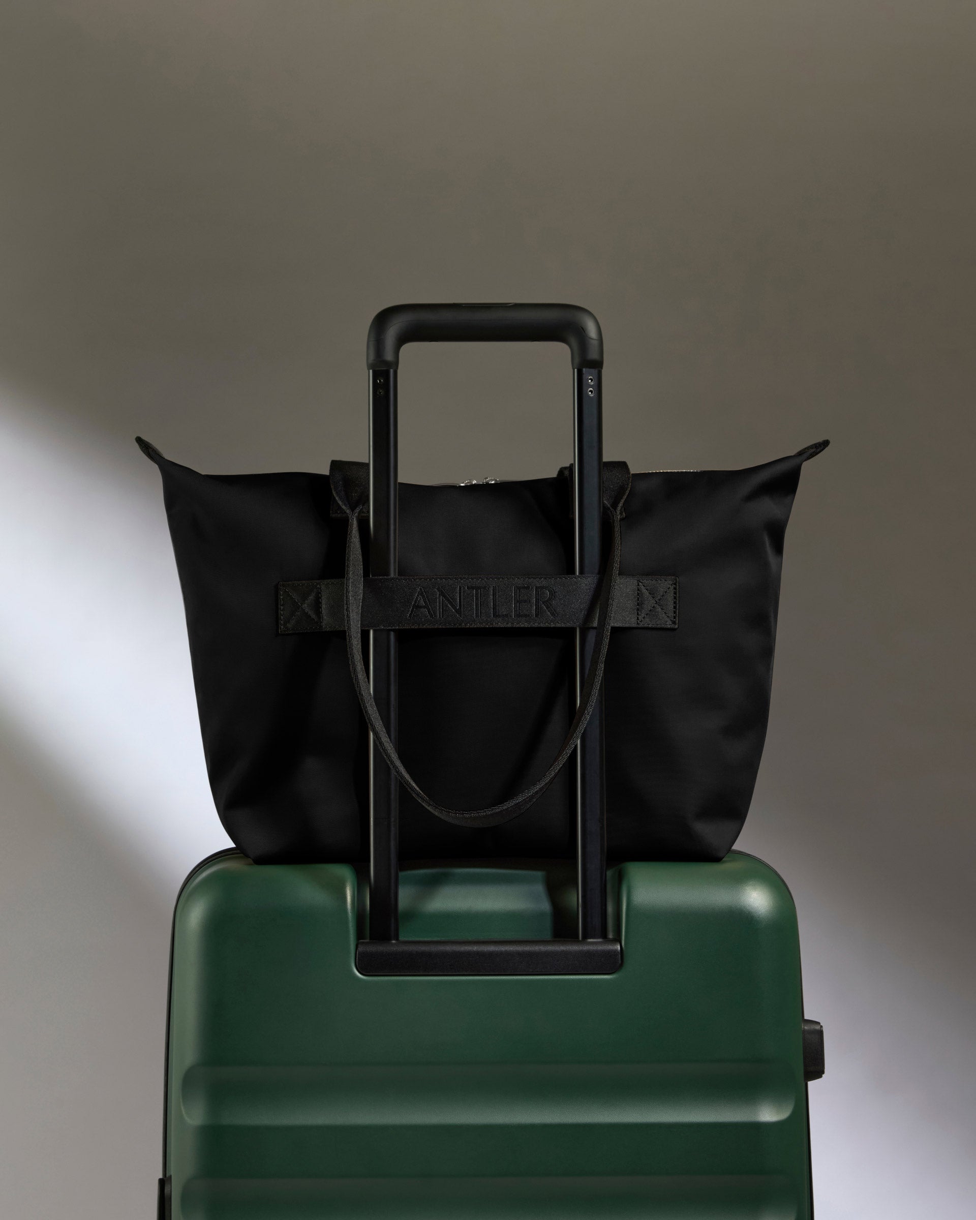a black bag on a green suitcase