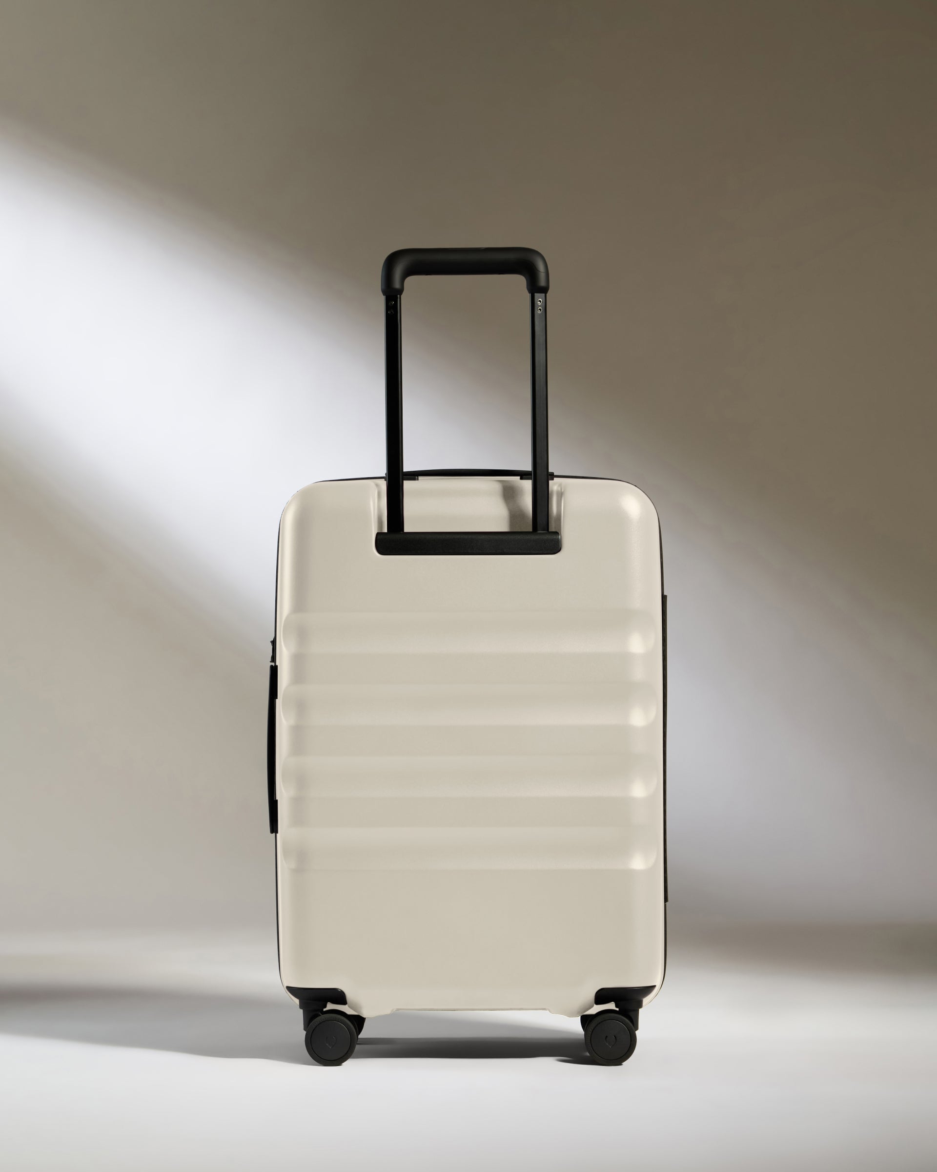 a white suitcase with black wheels
