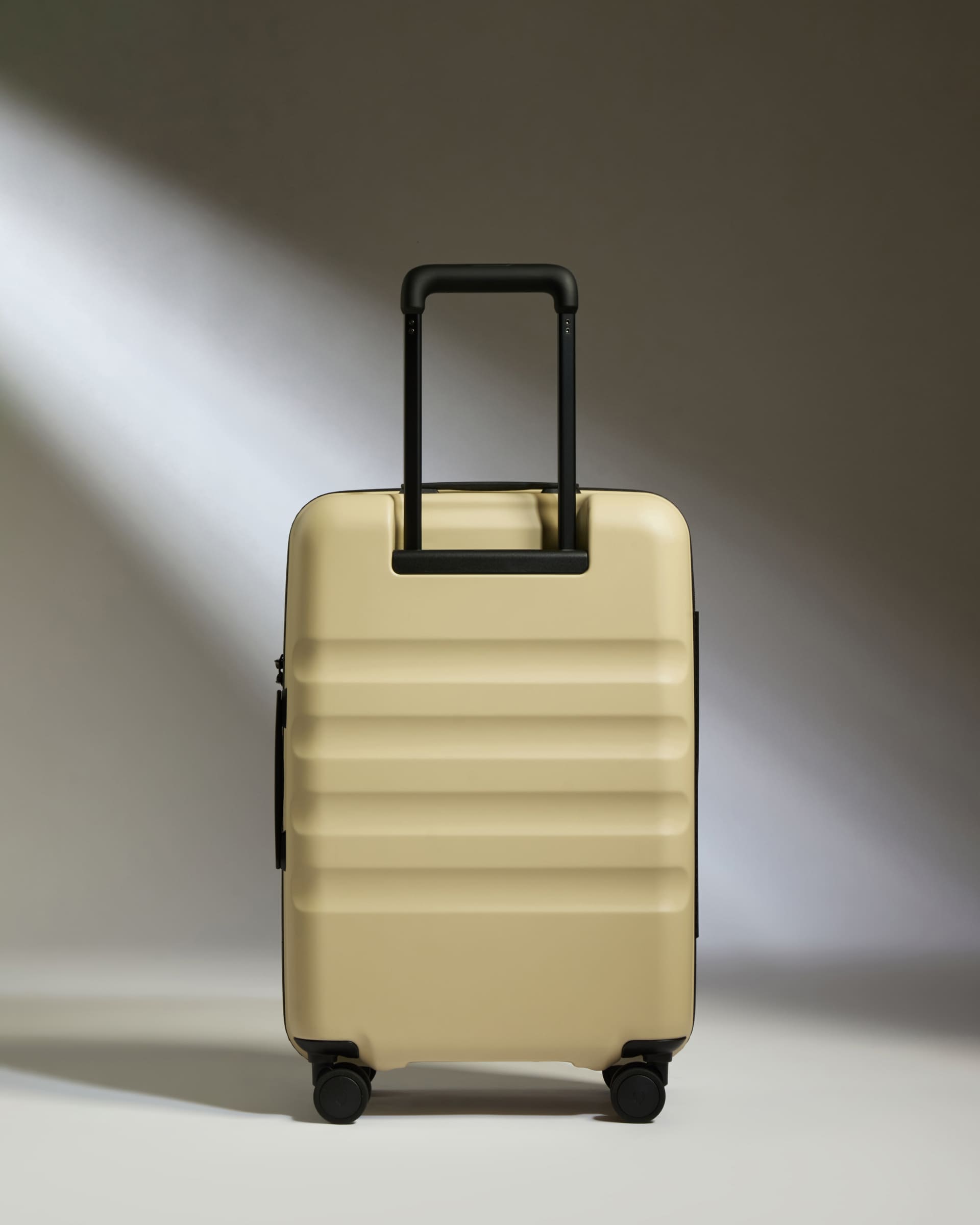 a tan suitcase with black handle