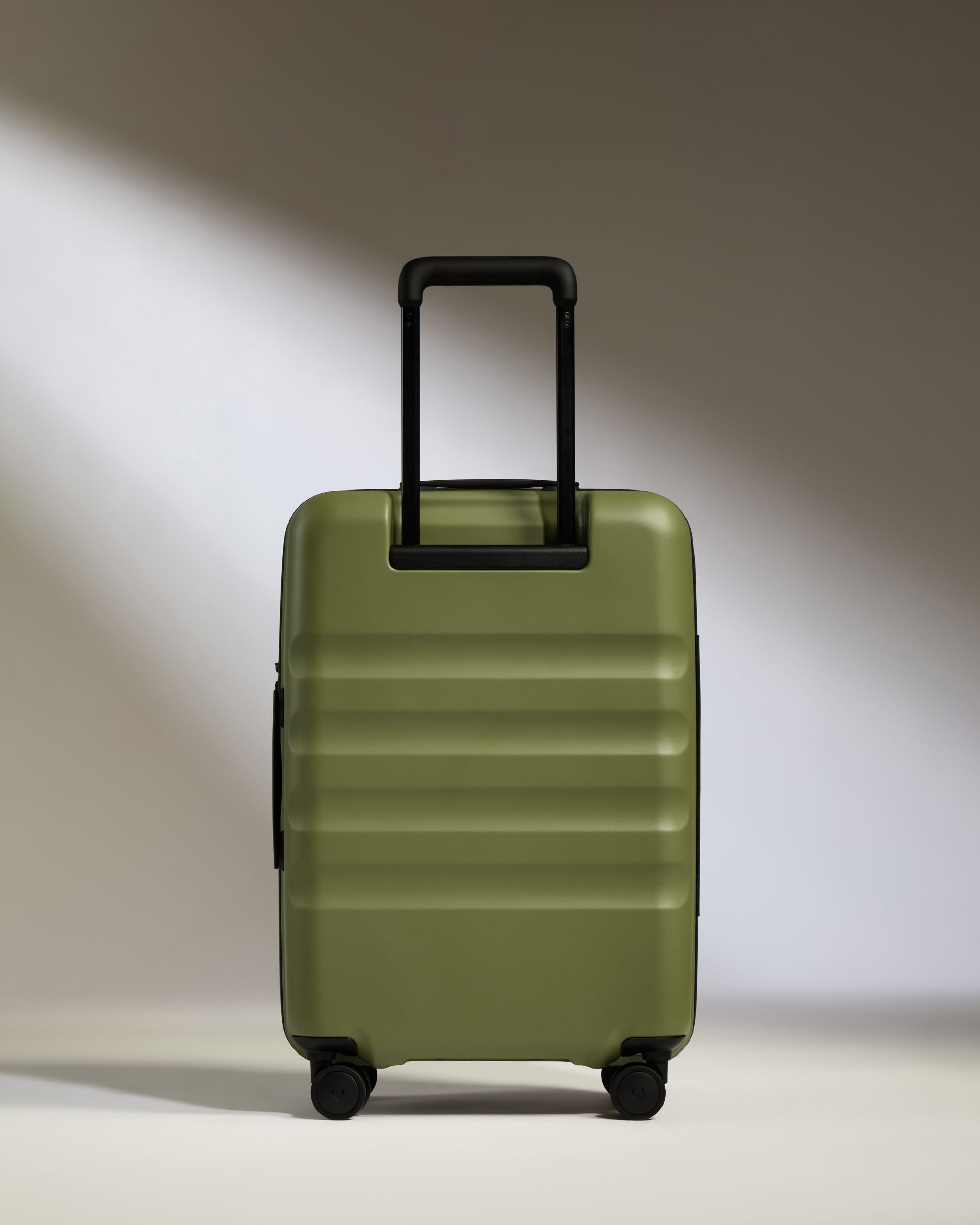 a green suitcase with black handles