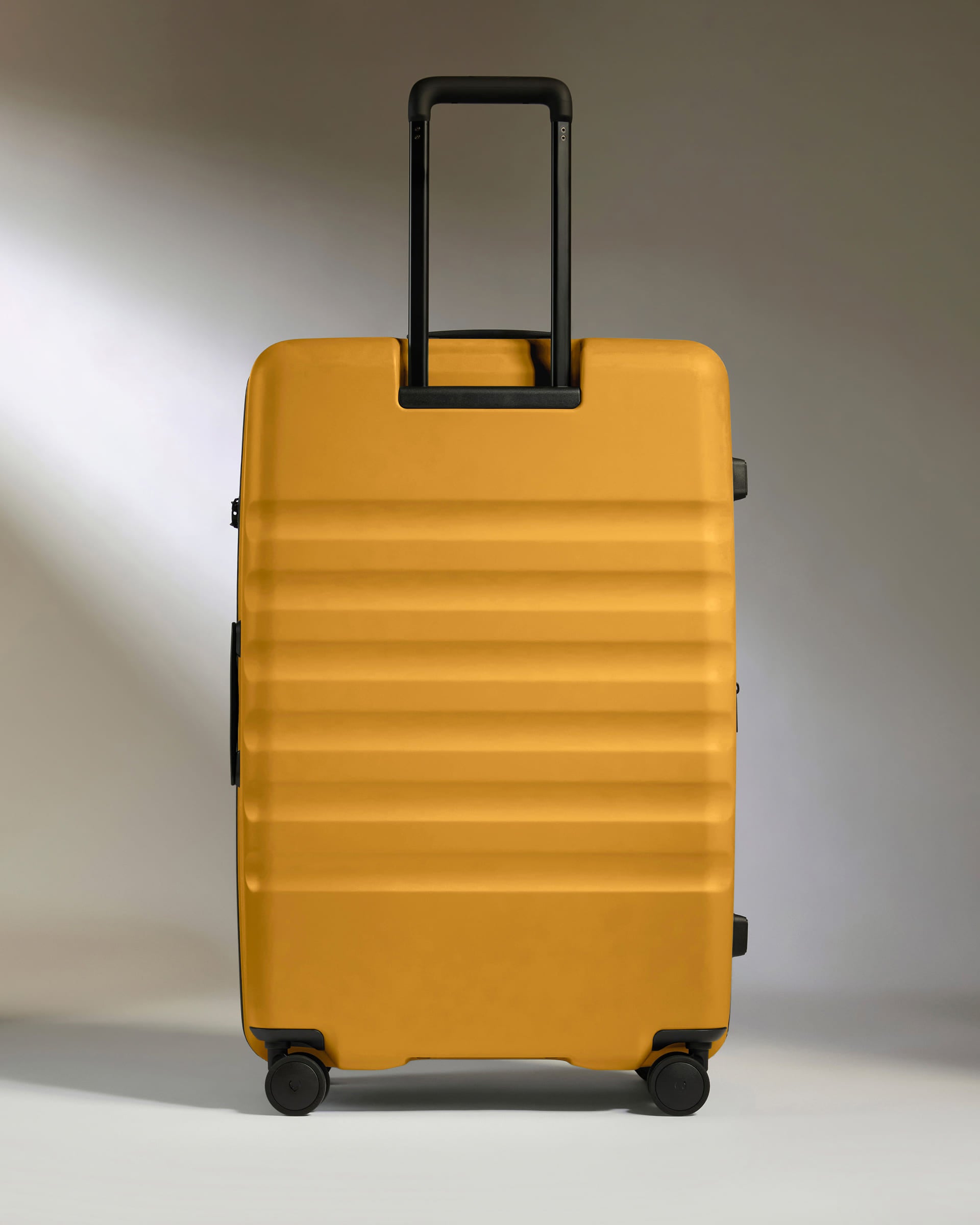 a yellow suitcase with black handles