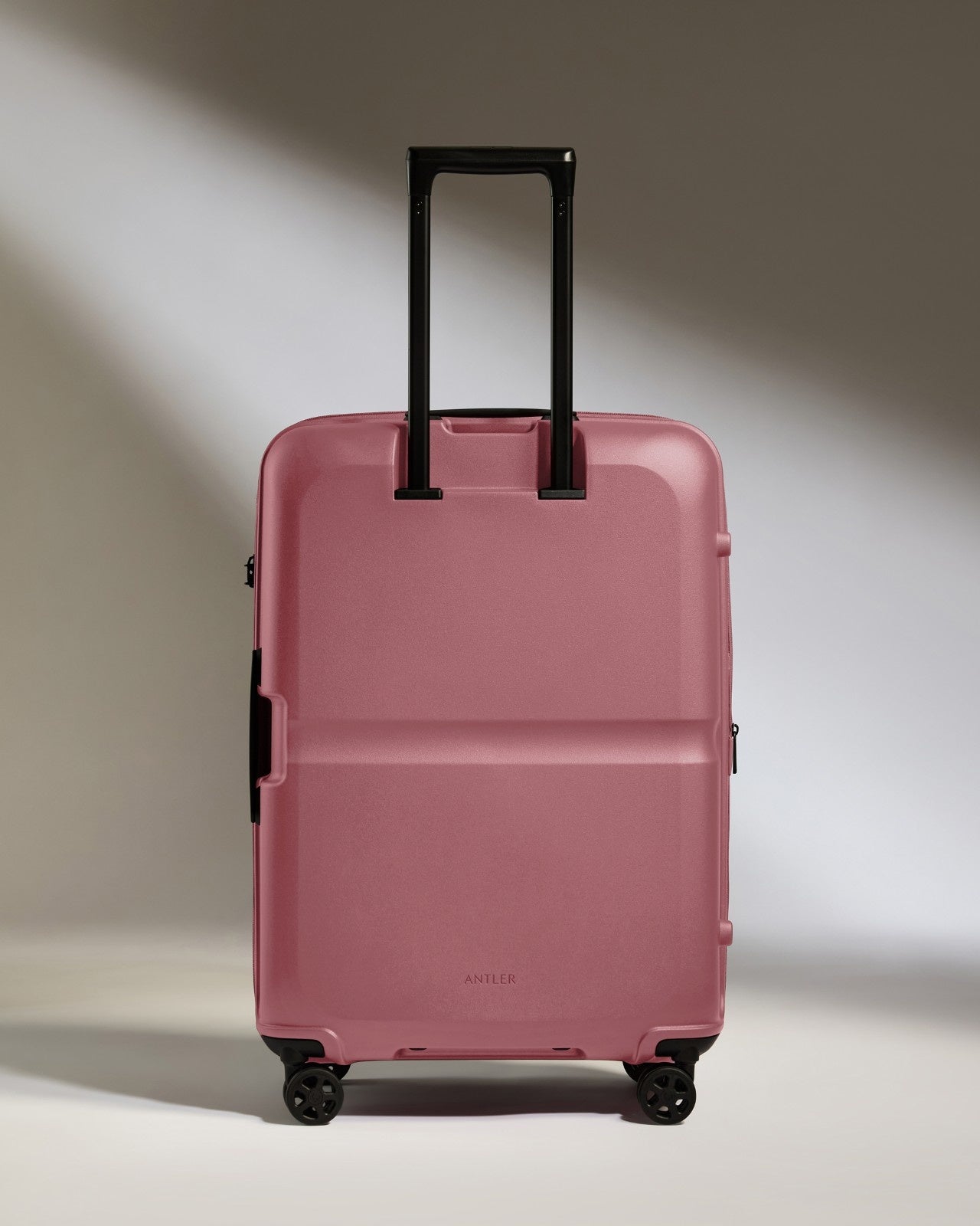 a pink suitcase with black handles