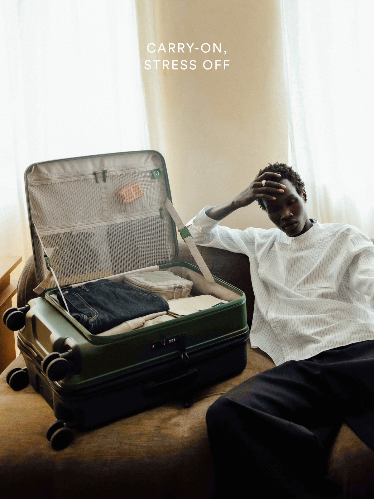 a man sitting on a couch with a suitcase