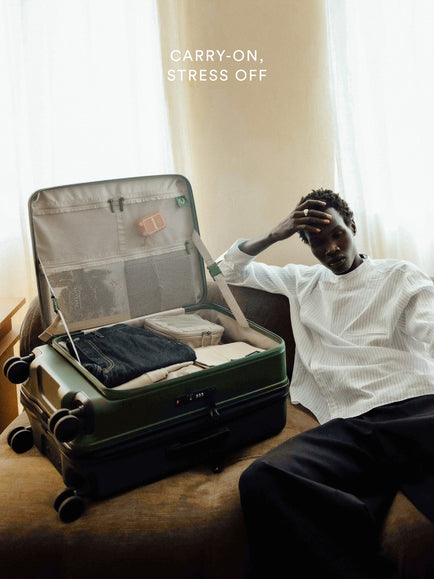 a man sitting on a couch with a suitcase