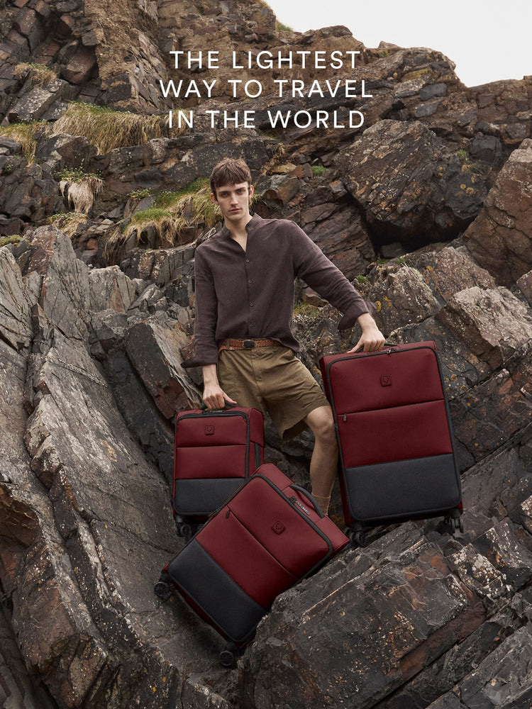 a man holding luggage on a rocky hill