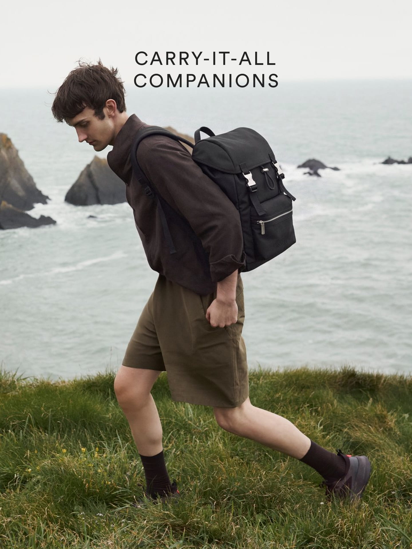 a man walking on a hill with a backpack