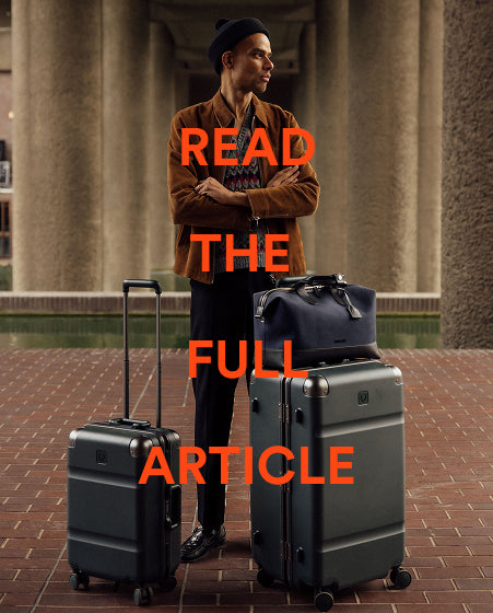 a man standing with his arms crossed next to luggage