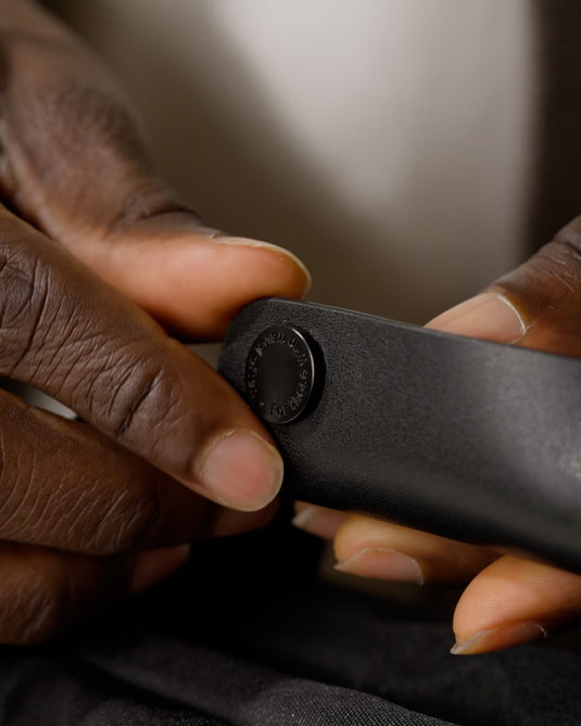 a close up of hands holding a black object