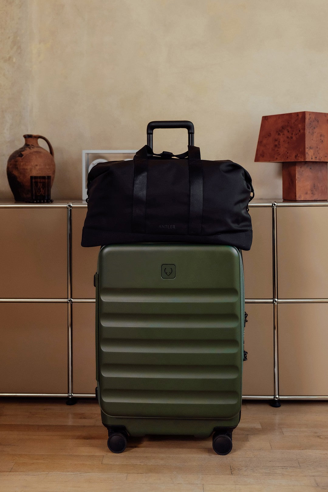 a black bag on top of a green suitcase