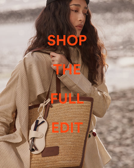 a woman with long brown hair and a bag
