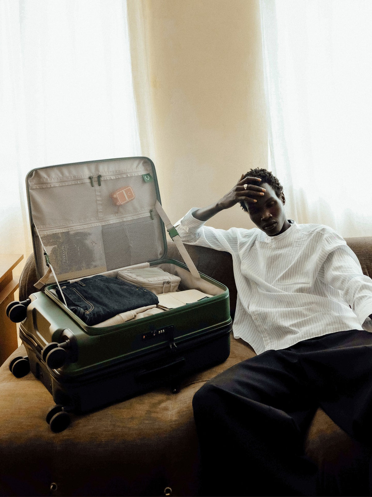 a man sitting on a couch with a suitcase