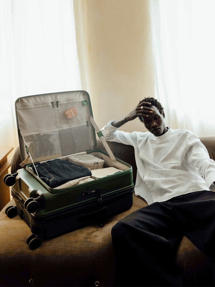 a man sitting on a couch with a suitcase